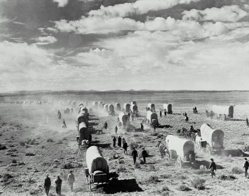 12. Поселенцы в крытых фургонах едут на запад Америки, примерно 1890 год