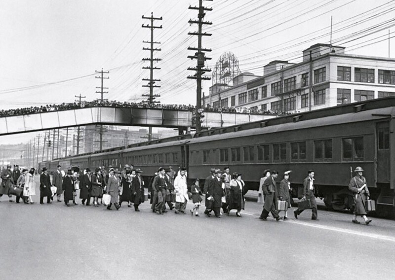 Горожане Сиэтла наблюдают с моста, как американцев японского происхождения отправляют в лагеря для интернированных. США, 1942 год