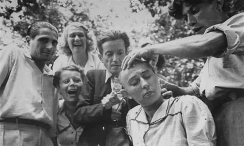 17. Люди смеются над тем, что женщине бреют голову. Снимок сделан после освобождения Марселя