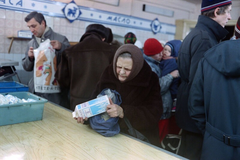 Пожилая женщина держит пакет молока в супермаркете в Москве. 11 декабря