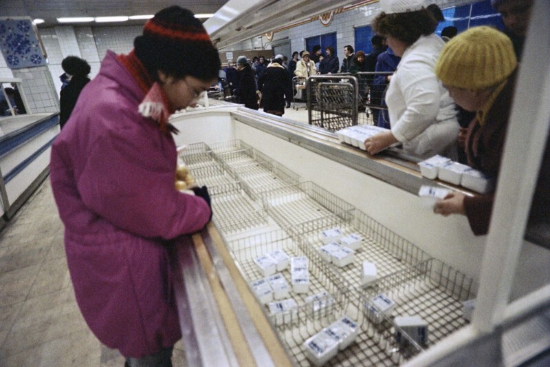 Женщина смотрит на пустые прилавки супермаркета в Москве, 11 декабря