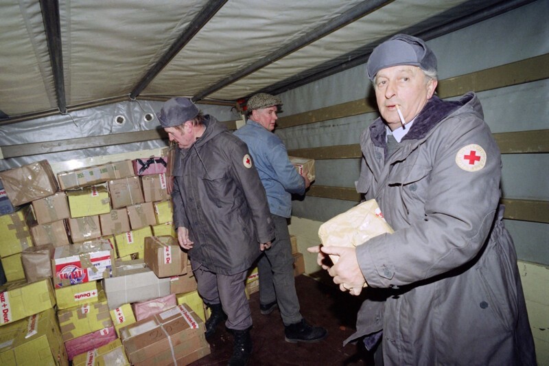 Члены Красного Креста Германии выносят продуктовые посылки из грузовика Красного Креста. 13 декабря