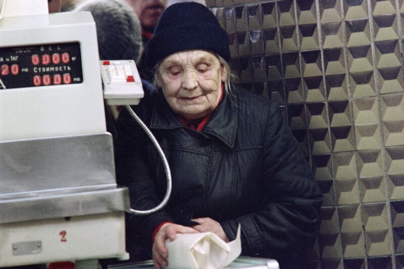 Пожилая женщина кладет продукты на весы в магазине в Москве, 14 декабря