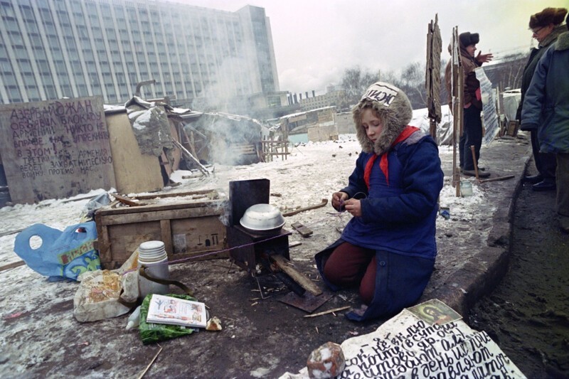 Бездомная девочка сидит у самодельных палаток возле Красной площади, 16 декабря