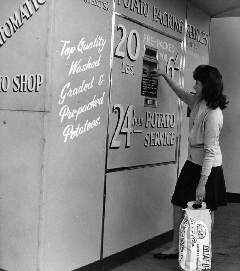 Женщина пользуется первым в Великобритании автоматом по продаже картофеля. Челси, 1962 год