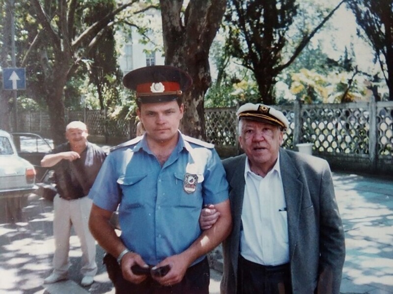 Сотрудник ГАИ фотографируется с легендой советского кино Юрием Никулиным, позади улыбается Марк Рудинштейн, середина 1990-х