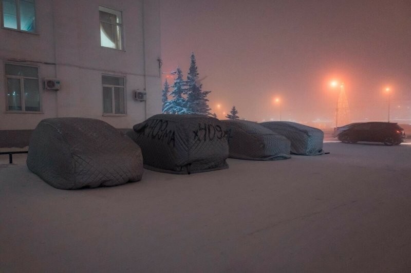 Припаркованные автомобили, укрытые чехлами на одной из улиц в Якутске. Температура около минус 50