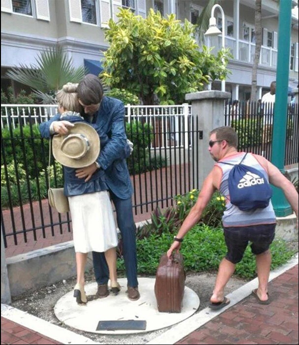 Растяпы!  Пока статуи стоят в обнимку чувак решил прибрать к рукам их чемодан. И ведь смешно получилось.