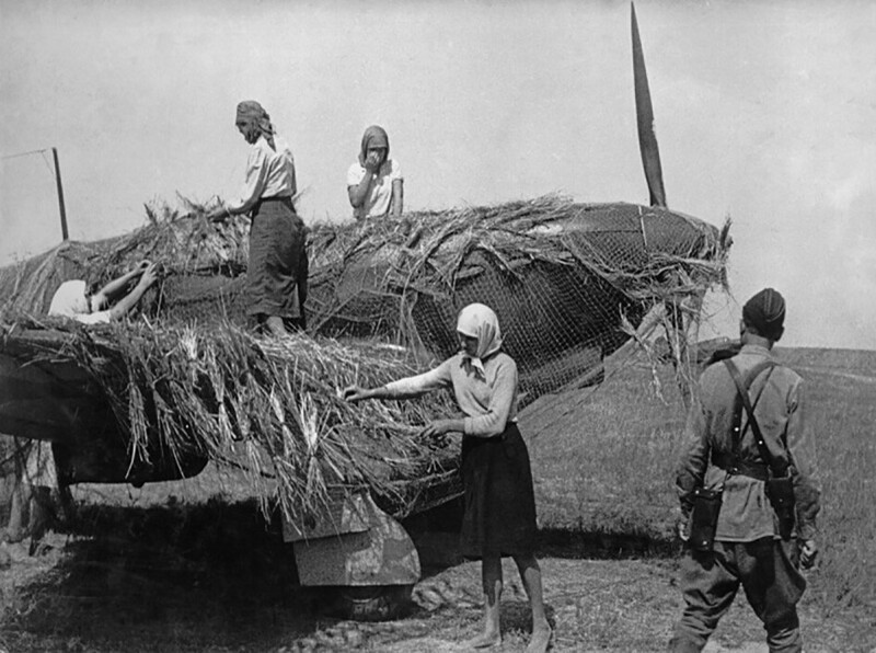 Женщины маскируют советский истребитель Як-1 на аэродроме. 1941 год