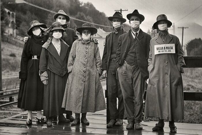 1. Пассажиры поездов в белых защитных масках, одна с плакатом «Носи маску или отправляйся в тюрьму», во время пандемии гриппа 1918 года в Калифорнии