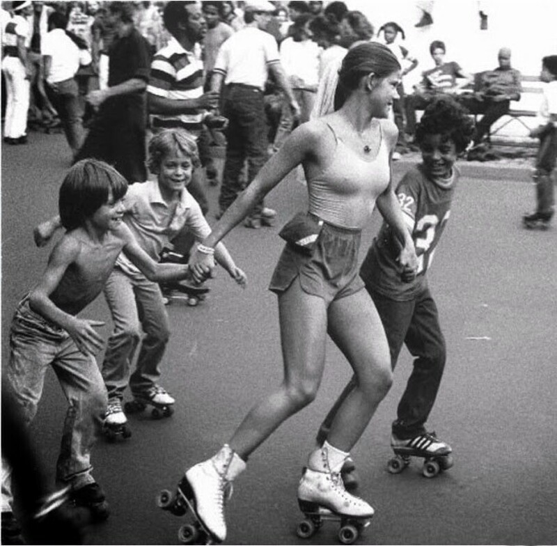 Симпатичная девочка-роллер катается с детьми на роликовых коньках.1970-е