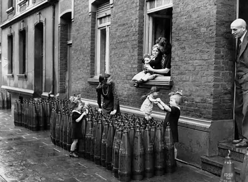 Голландские дети играют у 155-мм американских осколочно-фугасных гаубичных снарядов М107 на улице города