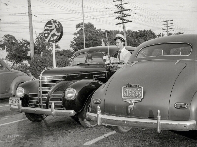 Официант придорожной быстрой закусочной разносит еду и напитки в автомобили посетителей в городке Чеви Чейс (штат Мэриленд, США), июль 1942 года