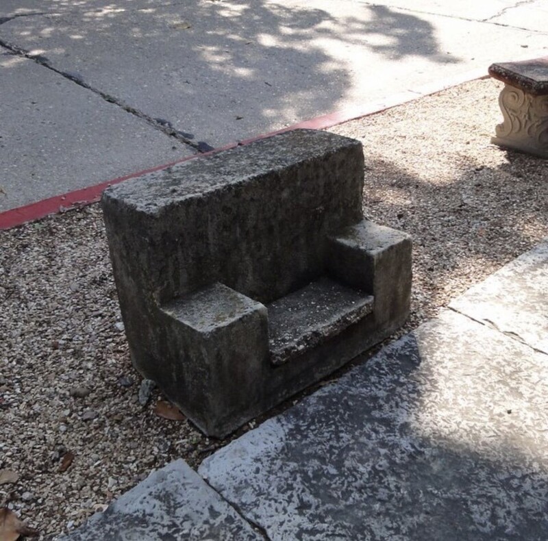 Очень маленькая бетонная скамейка или сиденье, обращенное в сторону от дороги возле бордюра