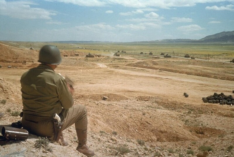 Генерал Джордж С. Паттон наблюдает, как его войска продвигаются через долину Эль-Геттар, Тунис, март 1943 года