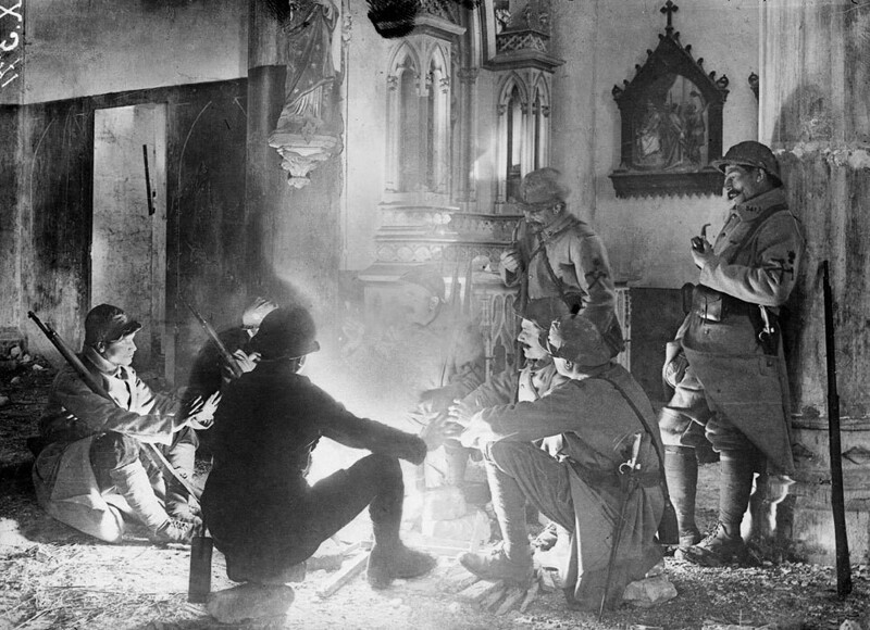 Французские солдаты разговаривают у костра внутри поврежденной церкви недалеко от Сен-Миеля, Франция, 1916 год