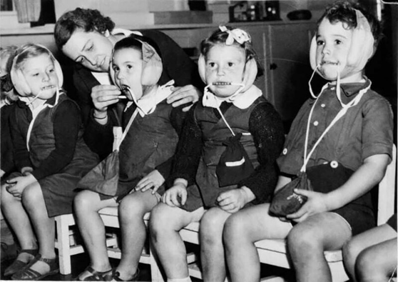 Австралийские дети в шапочках от бомбежки – наушники и защита от прикусывания языка, Сидней, 1942 год