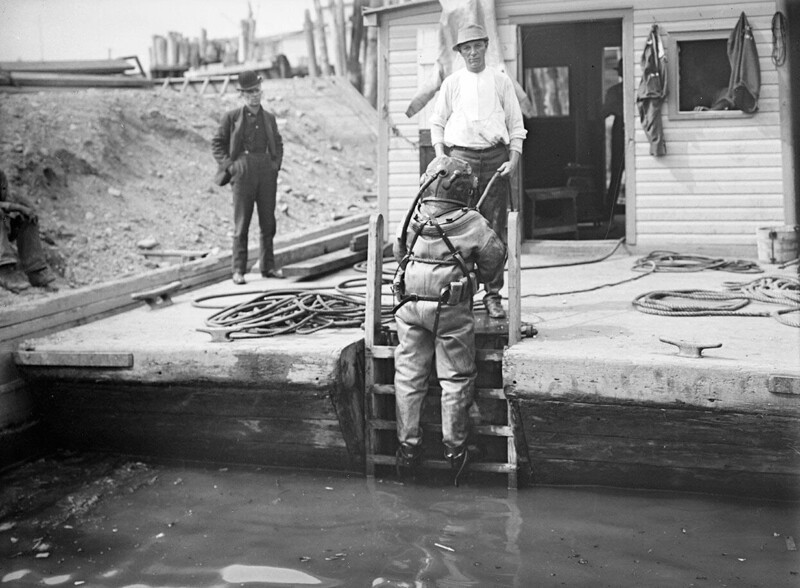 Мужчина в водолазном костюме готовится к погружению, около 1910 года. 