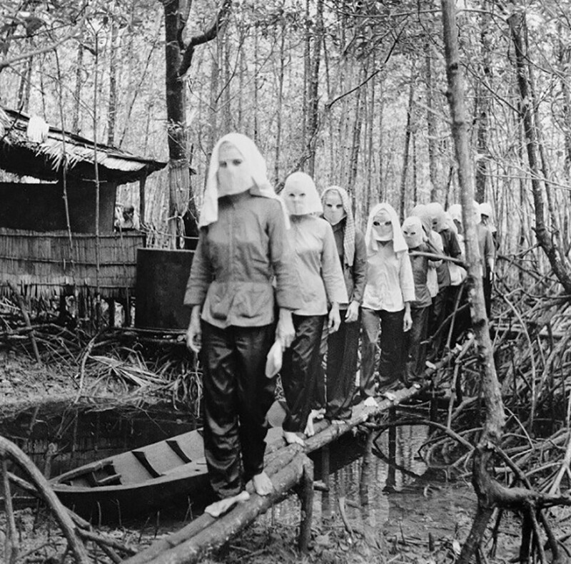 Сход партизанок в лесу в Намкане . Они скрывали лица под масками, чтобы оставаться анонимными, а значит – не иметь возможности выдать друг друга под пытками в случае попадания в плен. Война во Вьетнаме, 1972 год