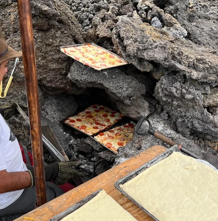 Мужчина готовит пиццу у вулкана Пакайя в Гватемале