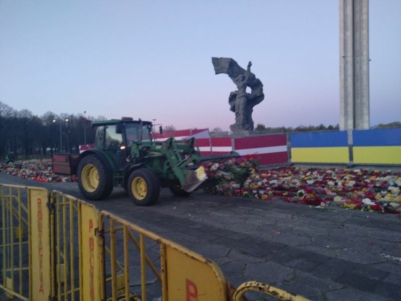 Цветы, которые жители Риги возложили к памятнику Освободителям, смели бульдозером