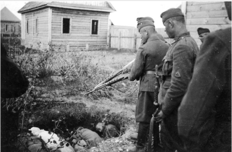 Венгерские солдаты с трофейными советскими винтовками СВТ-40 у ямы с расстрелянными советскими мирными жителями.