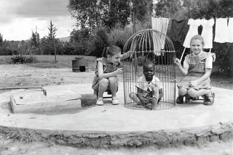 Бельгийские девочки играют с негритёнком в клетке для птиц, 1955 год