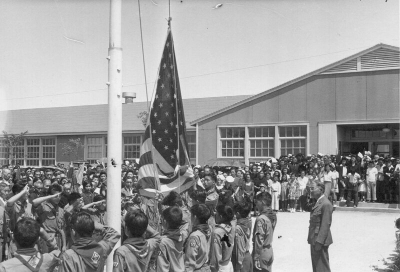 29. Американские бойскауты японского происхождения в лагере для интернированных в Гранаде приспускают флаг на церемонии поминовения родственников членов лагеря, погибших в бою в Италии. Колорадо, 1944 год