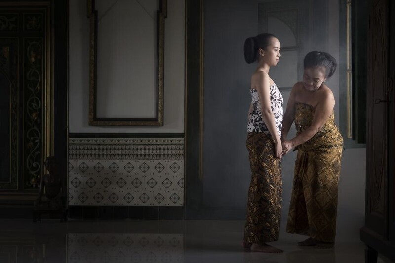 Традиции: мать и дочь надевают народную яванскую одежду, готовясь к традиционной танцевальной церемонии