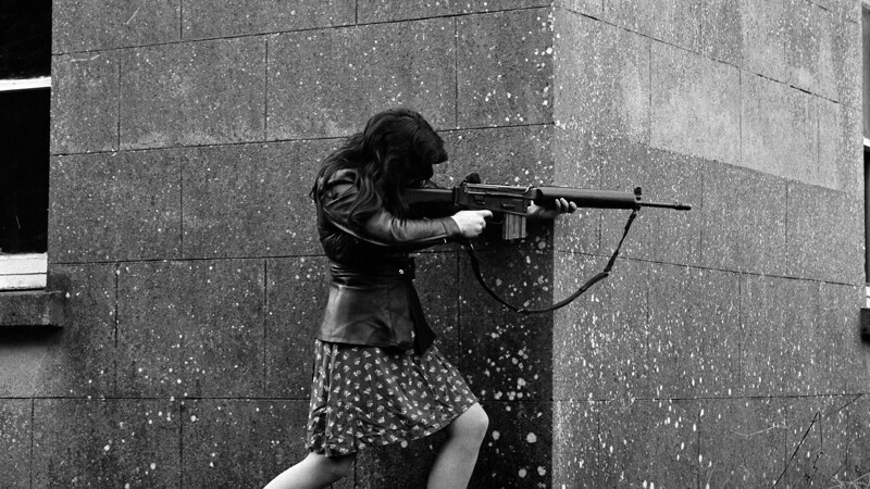Девушка-боец ИРА, вооруженная AR-18, стреляет в британских солдат во время уличной перестрелки (по некоторым данным - из оружия своего раненого в этой перестрелке жениха). Графство Антрим, Северная Ирландия, 1972 год.  