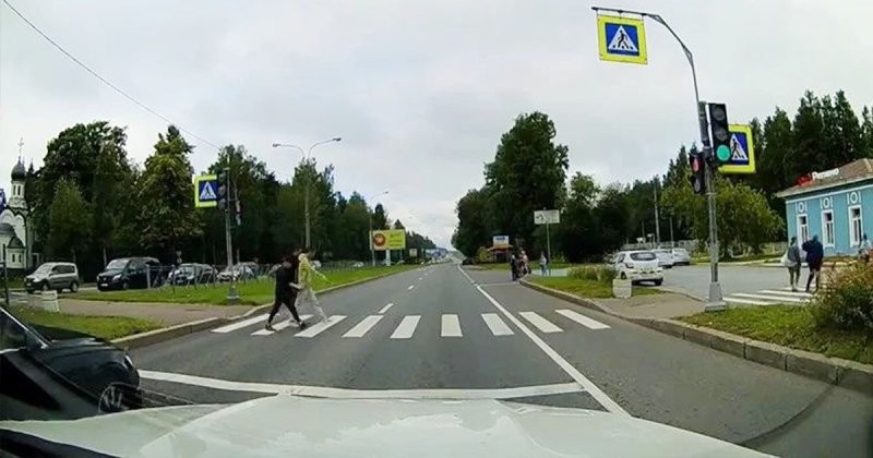 Беспечные пешеходы и быстрый мотоциклист встретились на регулируемом пешеходном переходе в Петербурге