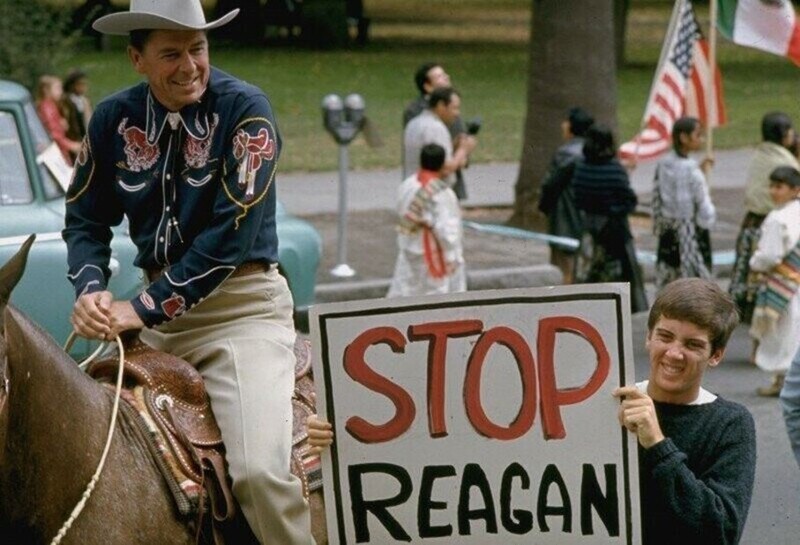 Рональд Рейган с протестующим во время избирательной компании на пост губернатора. США, 1966 год Рейган откровенно смеётся, глядя на протестанта с плакатом "Остановите музыку Рейгана"
