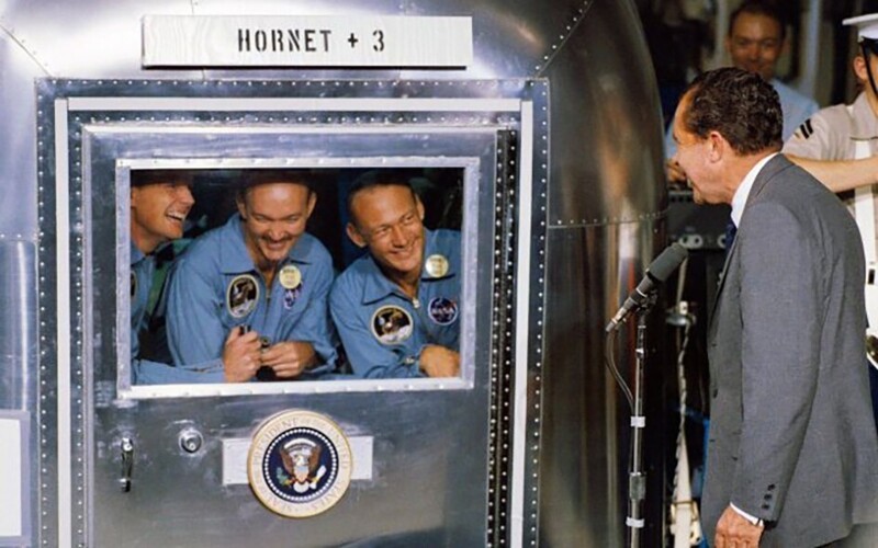 Американский президент Ричард Никсон навещает команду «Аполло 11», находящуюся в мобильной карантинной капсуле после возвращения с Луны