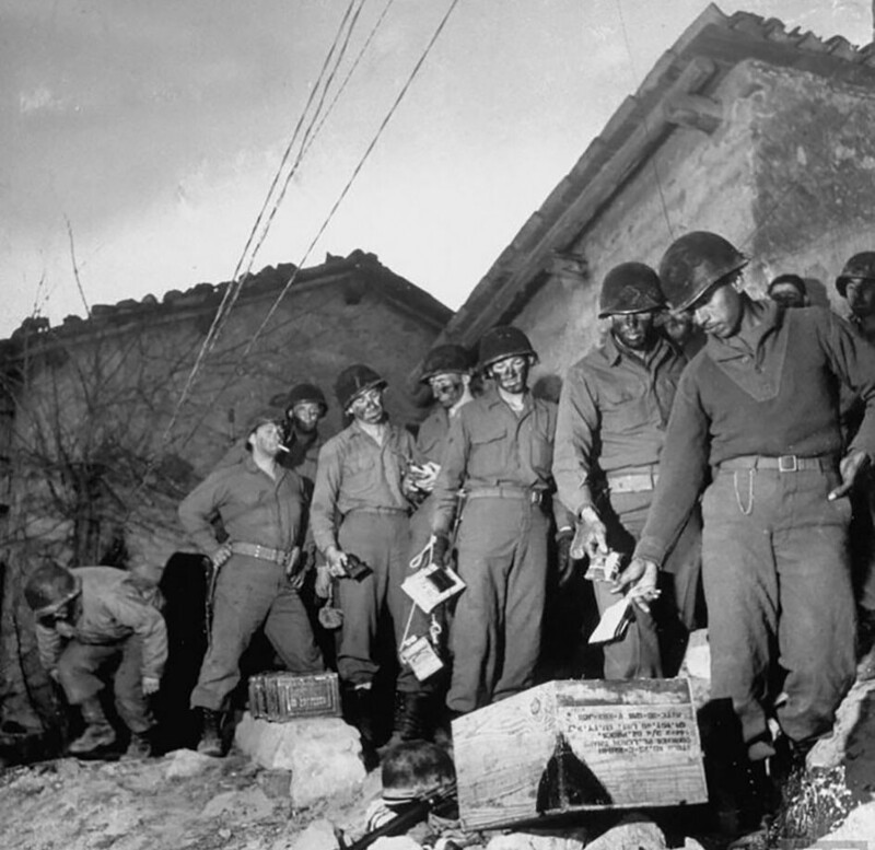 Американские пехотинцы бросают свои личные вещи в ящик, правила запрещают любую идентификацию, кроме бирок, при подготовке к ночному рейду на немецкие позиции. Италия. 1945 год