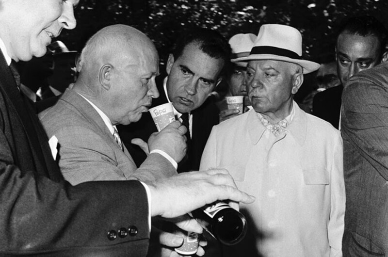 Никита Хрущев пробует Пепси в 1959 году на Национальной выставке США в Москве. За ним следят вице-президент США Ричард Никсон (в центре) и Дональд Кендалл (справа)