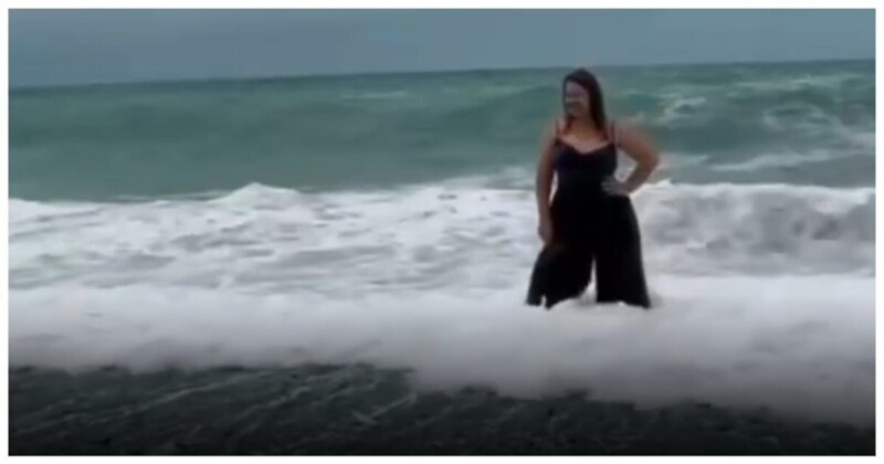 Попытка женщины сделать красивую фотографию на фоне моря