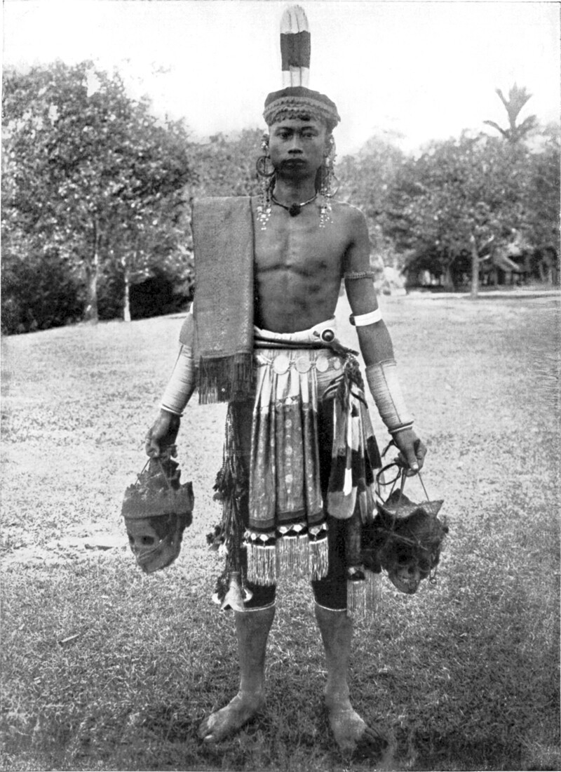 Мужчина показывает черепа людей, которых он убил на Борнео, Индонезия, в 1900 году. Местные племена брали головы врагов в качестве трофеев