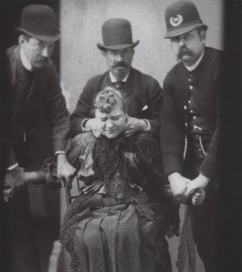 Сотрудники полиции держат женщину, чтобы сделать полицейскую фотографию в Нью-Йорке, в 1890 году