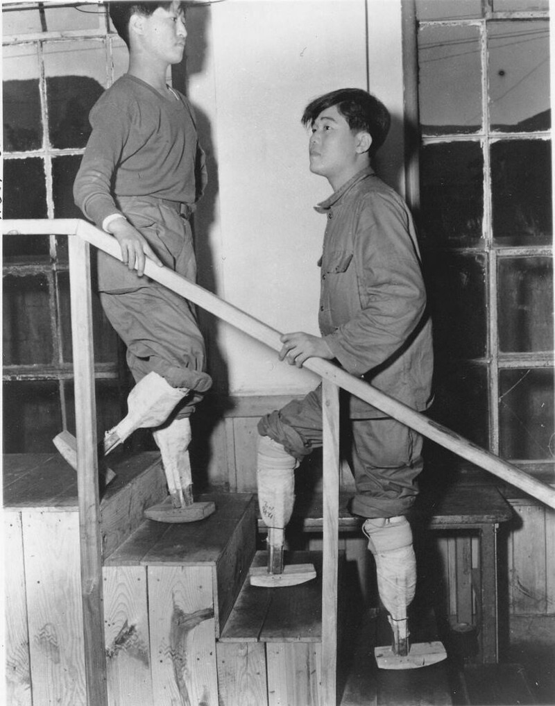 Два ветерана корейской войны с ампутированными конечностями демонстрируют свои экспериментальные протезы ног в Корее в 1955 году