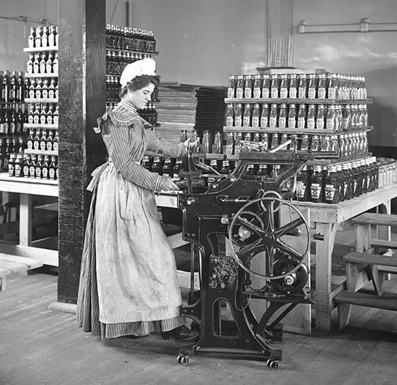 Работница, разливающая кетчуп по бутылкам на оригинальной фабрике Heinz, около 1897 год
