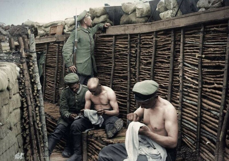 Немецкие солдаты в окопе ловят вшей в одежде. Восточный фронт. 1915 год