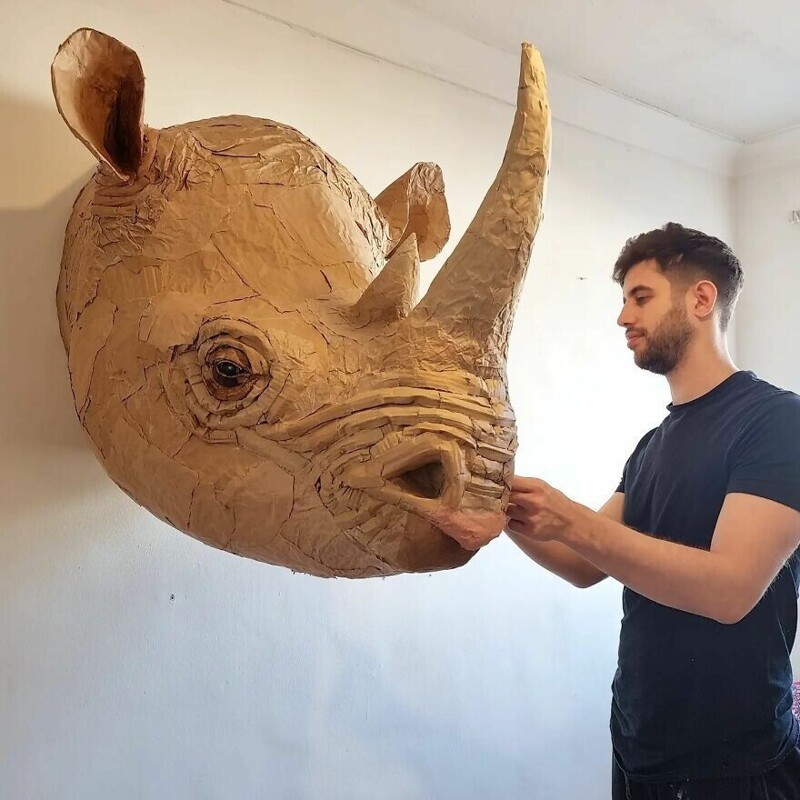 Парень мастерит скульптуры животных из картона и переработанных материалов
