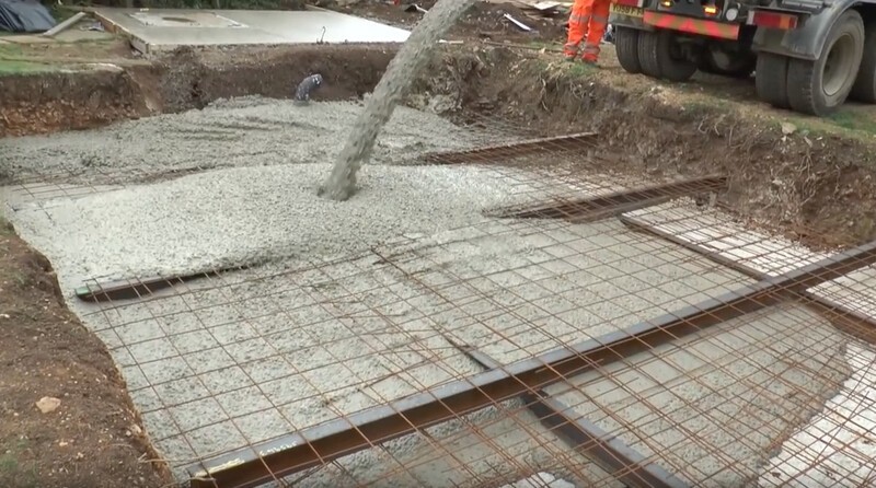 Несколько массивных несущих балок, протянутых по земле, призваны помочь распределить многотонный вес бетона