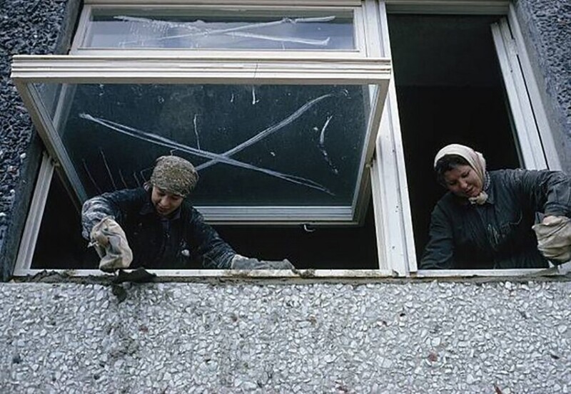 Женщины-строители устанавливают окна в новом квартирном доме