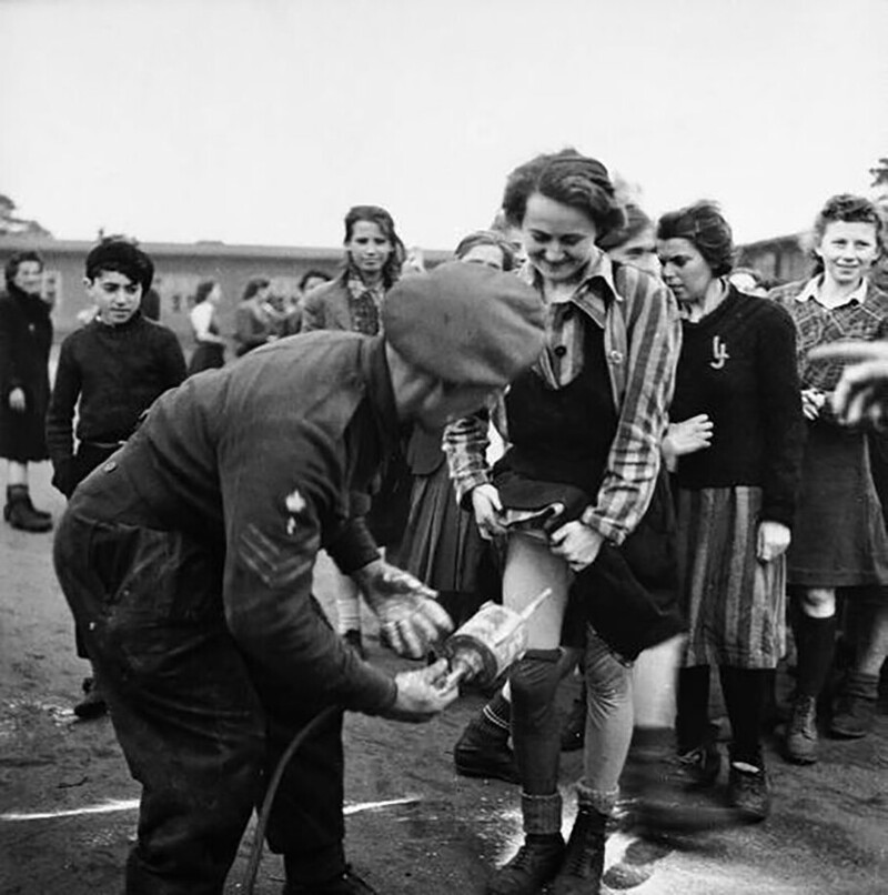Британский врач проводит дезинфекцию заключенных, только что освобожденных из концлагеря Берген-Бельзен, Германия, 1945 год