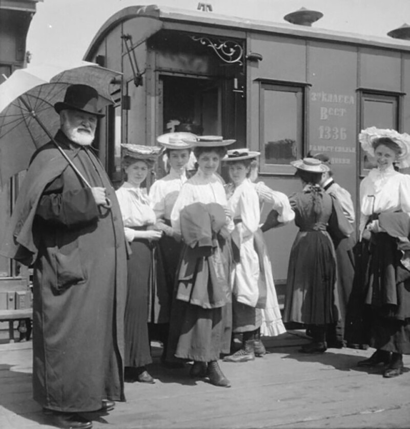 Гимназистки с сопровождающим у вагона поезда. 1900-е годы