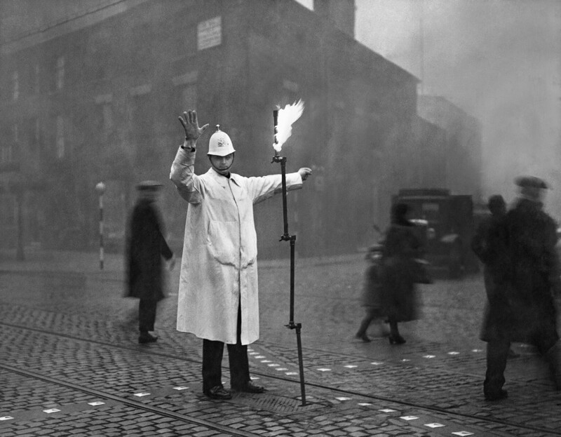 Полицейский управляет движением в лондонском тумане с помощью факела, 1935 год