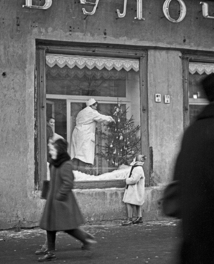 Девочка наблюдает, как украшают витрину булочной к Новому году, 1958 год