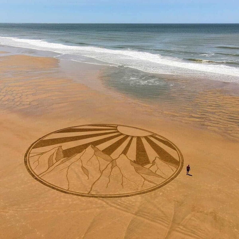 Художник делает огромные рисунки на берегу океана