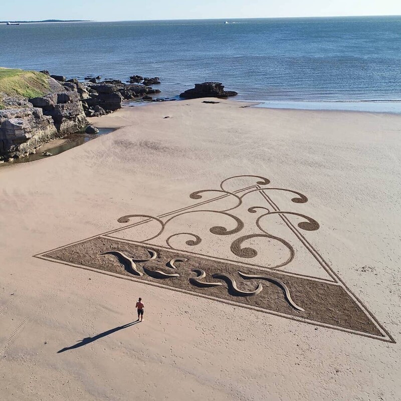 Художник делает огромные рисунки на берегу океана
